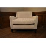 A contemporary armchair in cream calico upholstery on square tapering supports. H.80 W.90 D.70cm