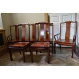 A set of six Chinese hardwood dining chairs with panel seats on shaped supports, to include two