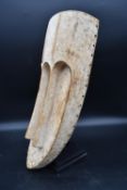 A tribal African carved wooden mask. H.57 W.30 D.9cm (mask) (adjustable stand)