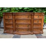 An American Colonial style bowfronted twelve drawer sideboard. H.97 W.191 D.56cm (some handles