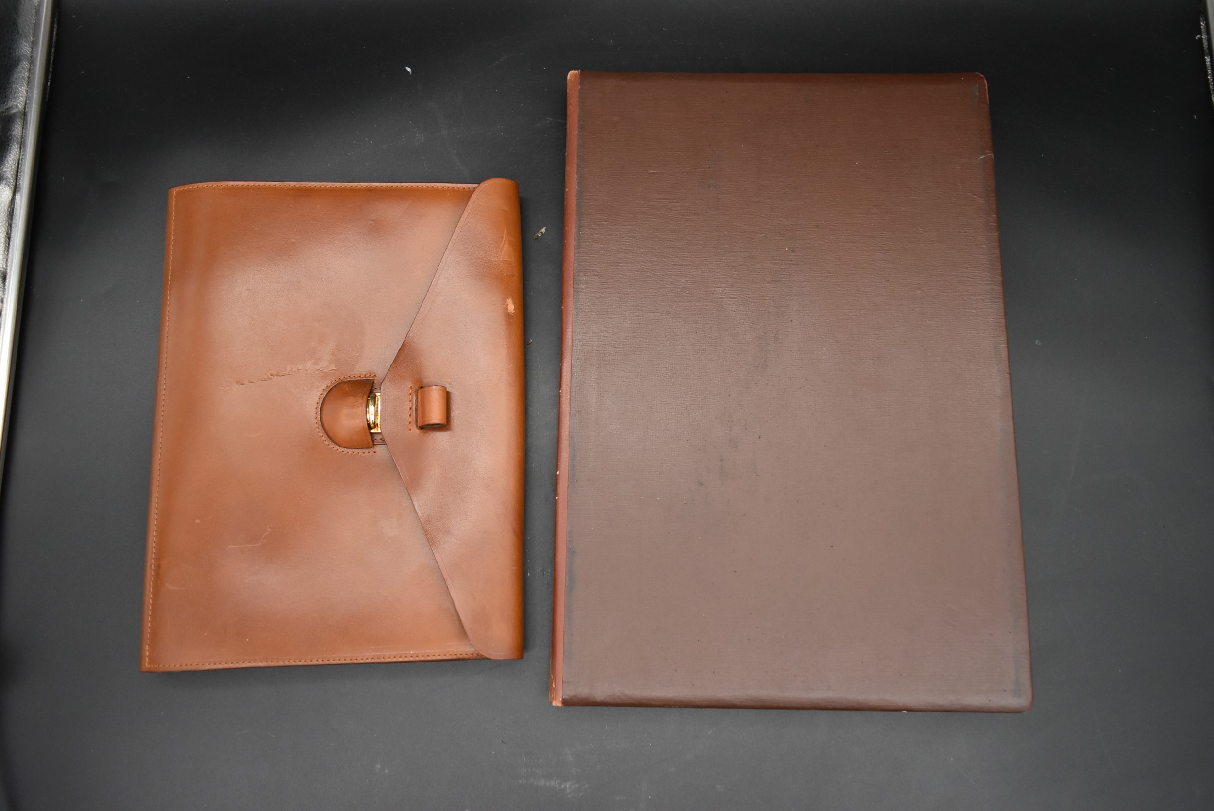 A vintage leather fronted stationary blotting pad along with a tan leather stationary folder with