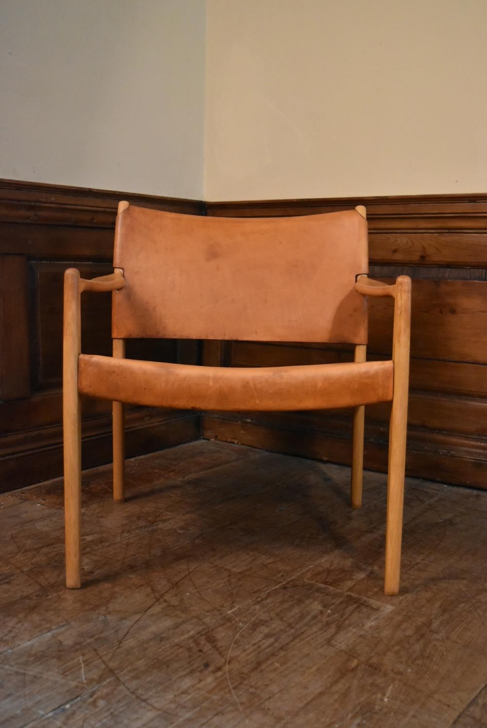 A mid century Scandinavian oak framed armchair with stretched light tan leather seat and back. H.