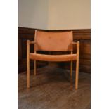 A mid century Scandinavian oak framed armchair with stretched light tan leather seat and back. H.