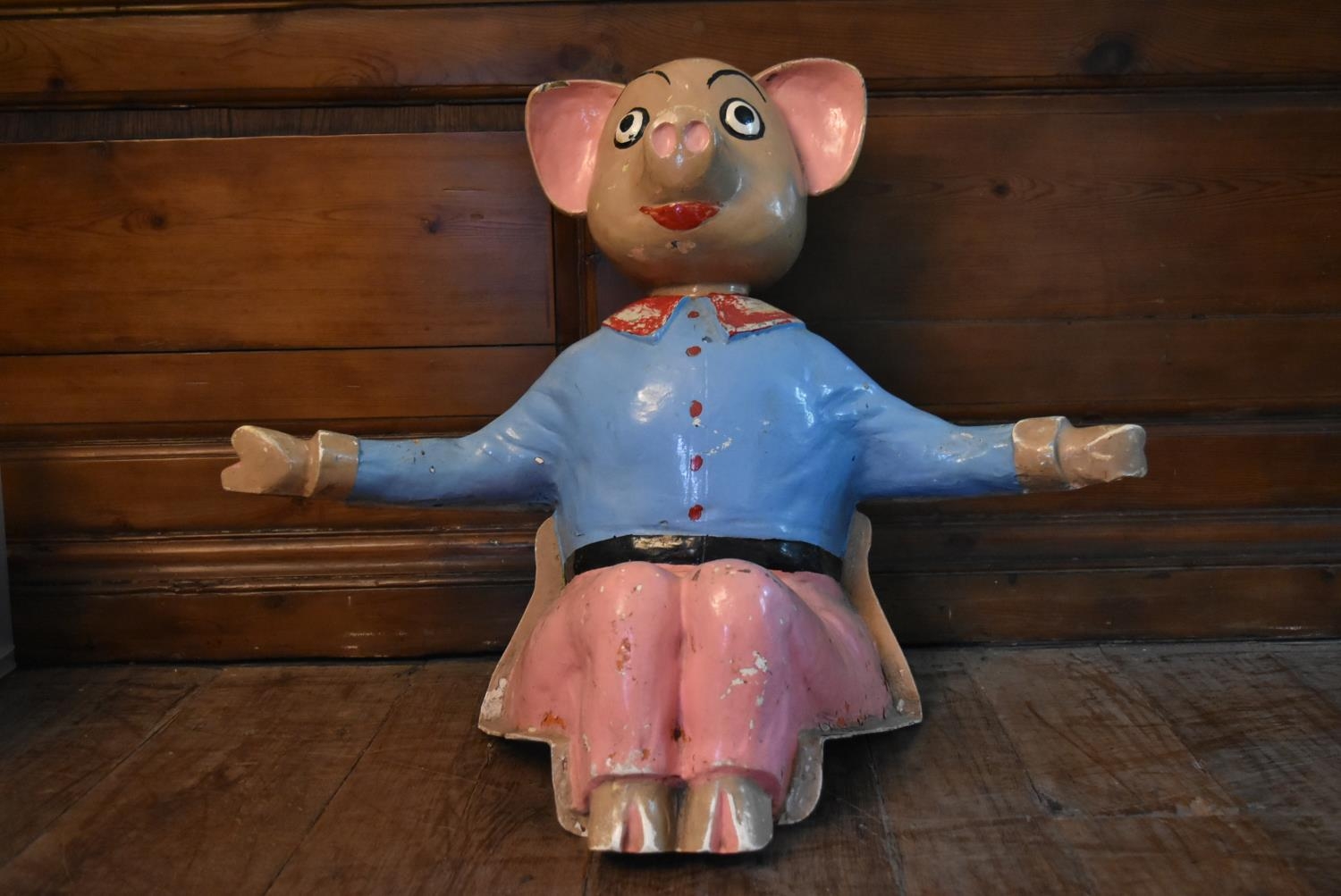 A vintage fibreglass seated figure of a cartoon pig. H.60 W.80 D.30cm