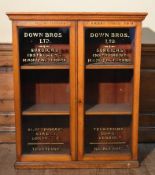 A late 19th century Down Bros Ltd light oak display cabinet; surgical instrument makers since