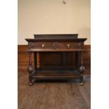 A mid century Jacobean style oak serving table with carved back above a pair of frieze drawers on