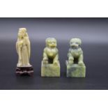A pair of Chinese carved jade Foo dogs on square bases along with a carved jade immortal on