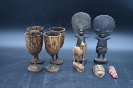 A pair of carved Ashanti fertility figures, a set of four carved goblets and other carved items. H.