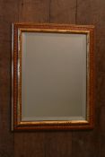 A wall mirror in gilt and painted frame with bevelled plate. H.50 W.38cm