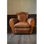 A vintage club armchair in piped tan leather upholstery. H.87 W.97 D.97cm (seat height.40cm)