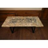 A mid century marble topped coffee table with square cut sections across the top raised on
