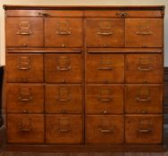 A large vintage oak filing cabinet fitted with a bank of sixteen drawers and a pair of slide out