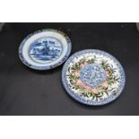 A Chinese blue and white plate and a Majolica plate decorated with cherubs. Dia.31cm (largest)