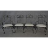 A set of four wrought metal conservatory dining chairs with cut floral upholstered seats on