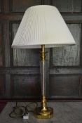 A glass and brass table lamp on stepped base. H.78cm W.15cm