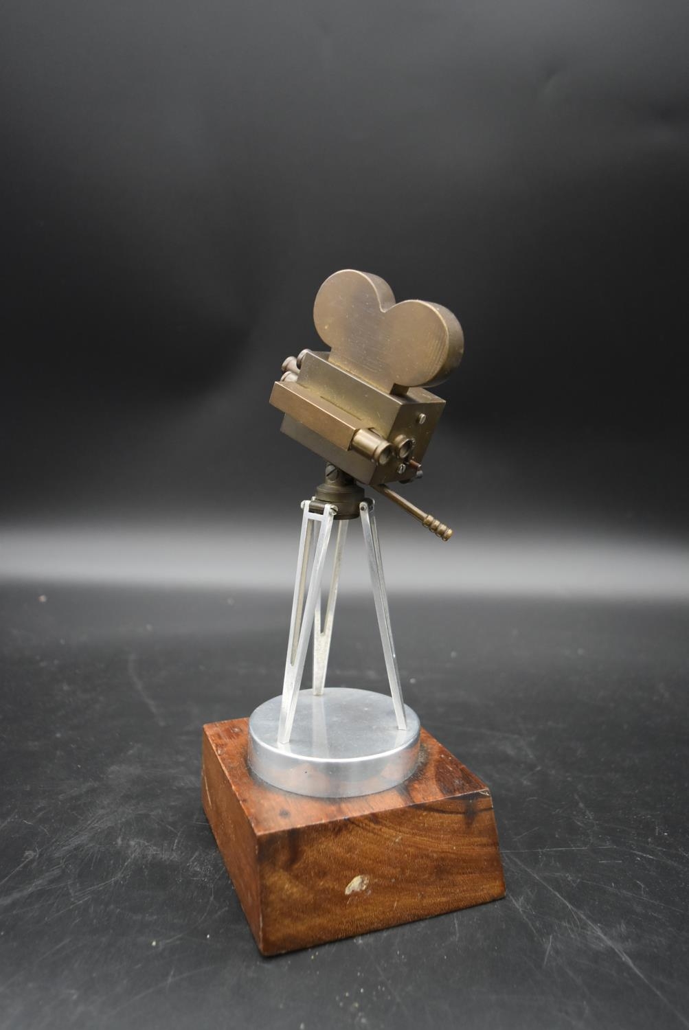 A brass and metal model of a 1930's film camera with hinged head on tripod base standing on wooden - Image 2 of 4