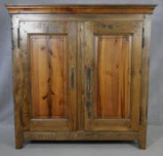 A 19th century style French Provincial elm armoire with panelled doors enclosing adjustable linen