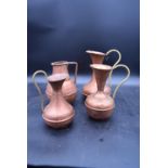 Four vintage copper and brass jugs. H.26 W.18cm