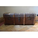 A vintage metal and teak bound travelling trunk. H.35 W.84 D.50cm