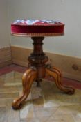 A Victorian walnut piano stool with tapestry embroidered seat on carved tripod base. H.46 Dia.