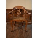 A Victorian oak captains style desk chair with caned seat on cabriole supports. H.90 W.64 D.50cm