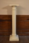 A vintage painted torchère with fluted column on stepped base.