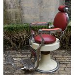 A vintage chrome adjustable barbers chair on metal base in faux leather upholstery with swivel