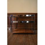 A Merrow Associates chrome framed drinks trolley with plate glass tiers on casters. H.64 W.73 D.46cm