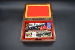 A 19th century mahogany box containing boxed Minitrix model railway carriages etc. H.13 W.26 D.