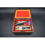 A 19th century mahogany box containing boxed Minitrix model railway carriages etc. H.13 W.26 D.