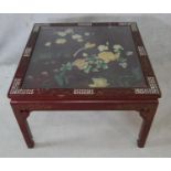 A Chinese black lacquered coffee table with bevelled plate glass drop in top, applied bird and