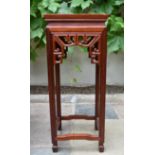 A Chinese carved hardwood urn stand with pierced frieze on shaped square stretchered supports. H.