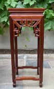 A Chinese carved hardwood urn stand with pierced frieze on shaped square stretchered supports. H.