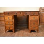 A mid century oak three section desk with inset leather top on block feet. H.77 W.124 D.66cm