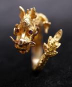 A Chinese 14 carat gold dragon form ring with wire detailing, engraved scales and ruby set eyes.