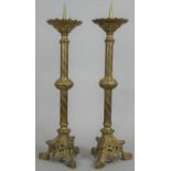 A pair of brass Ecclesiastic style pricket candlesticks on pierced and scrolling tripod bases. H.