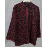 A black woolen crewel work jacket, embroidered with flowers and leaves, with toggle fastenings. L.