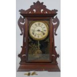 A late 19th century American walnut cased mantel clock with enamel dial and eight day movement by