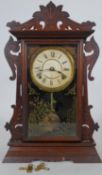 A late 19th century American walnut cased mantel clock with enamel dial and eight day movement by