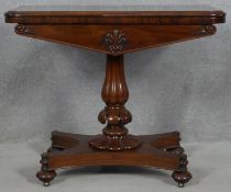 A William IV mahogany foldover top card table with baize lined surface on reeded bulbous pedestal
