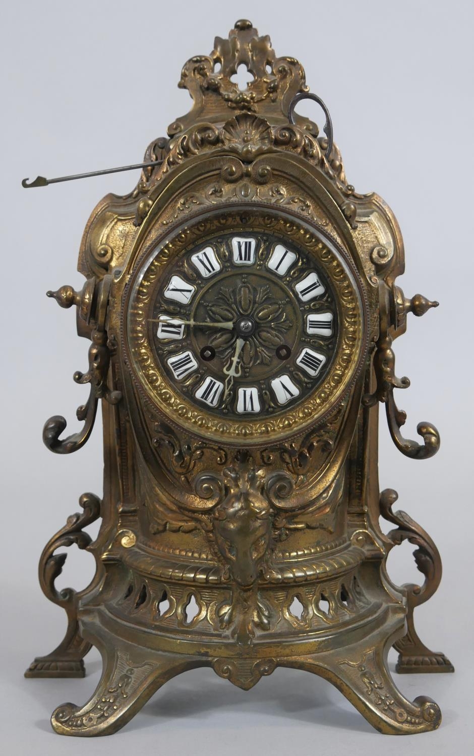 A French style brass mantel clock in scrolling Rococo case with enamel Roman numerals and eight