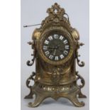 A French style brass mantel clock in scrolling Rococo case with enamel Roman numerals and eight
