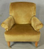 A contemporary Victorian style armchair in velour upholstery on turned supports terminating in cup