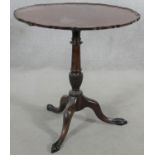 A Georgian style mahogany tilt top occasional table with pie crust edge on husk carved turned