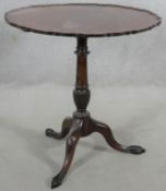 A Georgian style mahogany tilt top occasional table with pie crust edge on husk carved turned