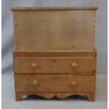 A 19th century pine mule chest with lidded coffer section fitted with candle slide above two drawers
