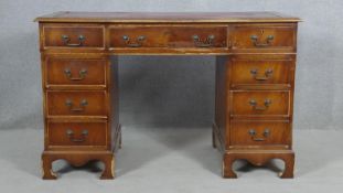 A Georgian style mahogany three section pedestal desk with inset leather top on shaped bracket feet.