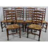 A set of six oak Lancashire ladderback dining chairs with woven rush seats on turned stretchered