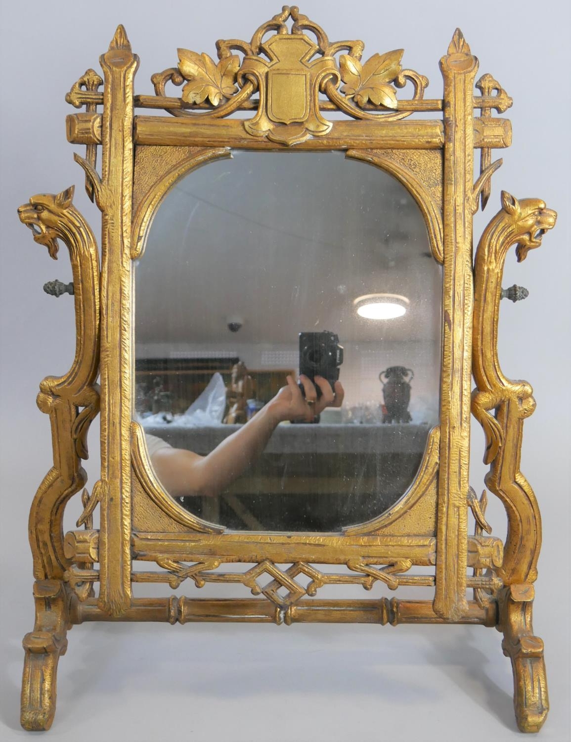 A large late 19th century carved giltwood swing toilet mirror in naturalistic foliate frame with