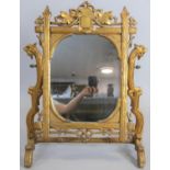 A large late 19th century carved giltwood swing toilet mirror in naturalistic foliate frame with